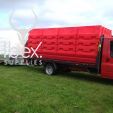 Van carrying large stacks of Evo water filled barriers in red and white