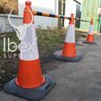 Black and yellow telescopic demarcation poles linked to orange and white traffic cones in a line