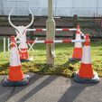 Red and white telescopic demarcation poles linked to orange and white cones around a pole