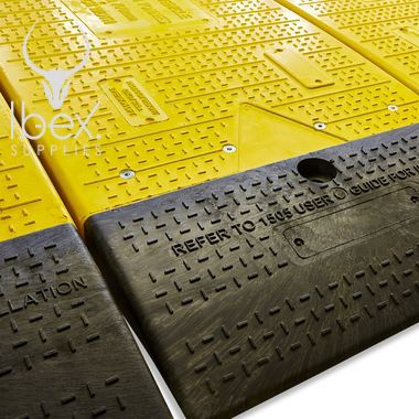 Close up of yellow and black GRP road plate on white background