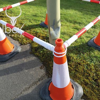 Red and white telescopic demarcation poles linked around orange and white cones